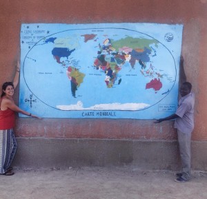 Peace Corps volunteer Natalie Moore displays a world map project she helped with at an elementary school in Burkina Faso with the director.  Source: Natalie Moore